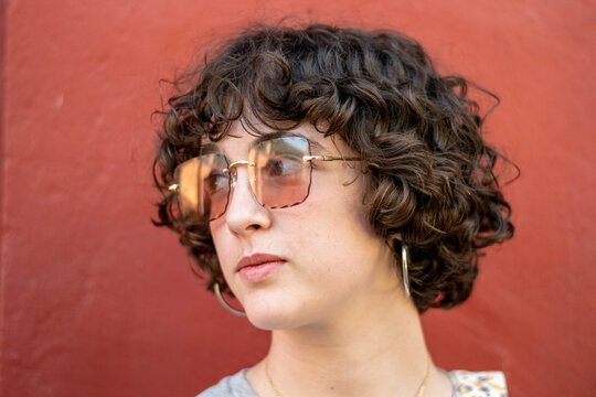 Retrato de joven con el pelo rizado y gafas de sol grandes en distintas aptitudes.
