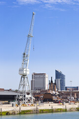 Fototapeta na wymiar A traditional dockyard crane overlooking HMS Victory ( Lord Nelson's flagship at the Battle of Trafalgar in 1805) in Portsmouth Historic Dockyard, Portsmouth, Hampshire UK