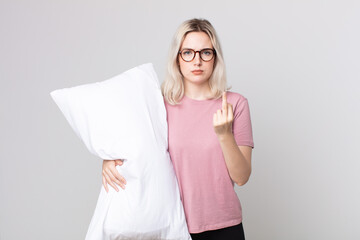 young pretty albino woman feeling angry, annoyed, rebellious and aggressive wearing pajamas and...