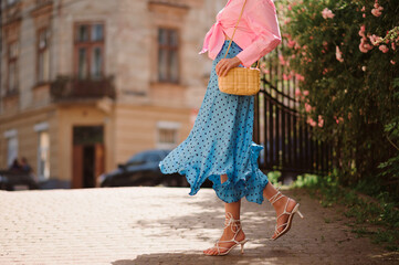 Summer street fashion details: elegant woman wearing trendy pink shirt with knot, polka dot blue...