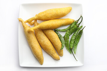 Indian street food tea time snack Green Chilli Pakoda served in a ceramic plate
