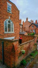View of the back wall of a red brick residential building with a large white window