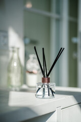 An aromatic reed diffuser stands on a table against a blurry background.