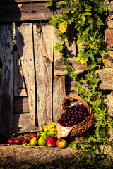 Vertical still life of fruits with cherries as protagonists in a wicker basket and rustic look....