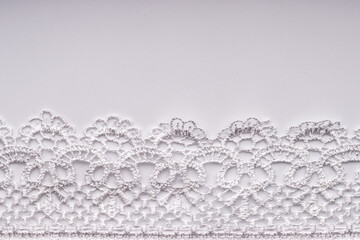 White lace on a white background. - obrazy, fototapety, plakaty