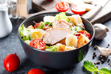 A delicious chicken caesar salad with parmesan cheese, dressing and croutons