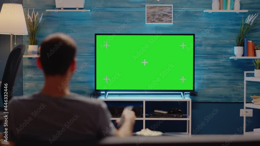 Poster man using tv remote on green screen background at home. mockup template display used for isolated me