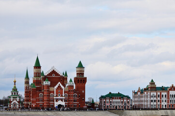 The building is in the form of a castle of red and white brick next to the building in the Dutch style. Russia Yoshkar Ola 01.05.2021. High quality photo