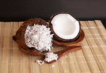 Closeup shot of grated coconut on wooden matt with a spoon