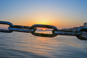 Сhain link fence and sea sunset
