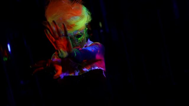fluorescent makeup and wig on sexy lady, glowing in ultraviolet light