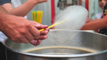 The process of making cotton candy on the street.