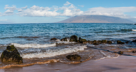 North Maui and Exposed Lava on The Beach of Kamole Beach Park II, Maui, Hawaii, USA