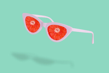 Trendy summer idea made of sunglasses and fresh slices of grapefruit.