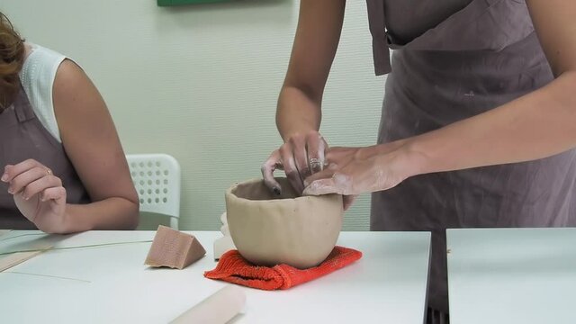 Woman hand potter making clay cup in pottery workshop studio. Process of creating ceramic mug. Handmade, hobby art and handicraft concept.