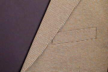 Detail of men outwear, light beige blazer on brown background with copy space. 