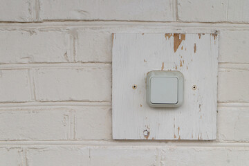 switch on a wooden stand on a white brick wall