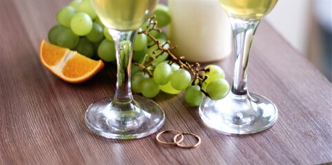 glass of champagne with grapes and wedding rings