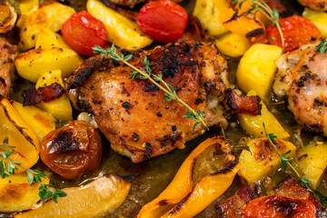 Roasted chicken thighs with potatoes, vegetables and rosemary - top view