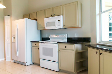 empty brightly lit modern kitchen with appliances
