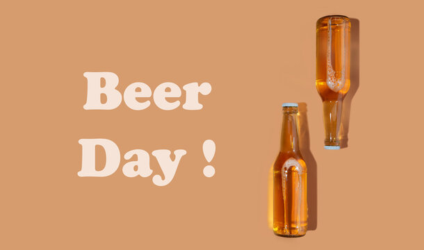 A bottles of craft beer on beige background. International beer day or Octoberfest concepts.Text beer day.Resting and Drinking beer after a hard working day in the home.Minimalistic colors on a photo