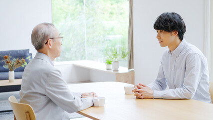 会話をする若い男性とシニア男性