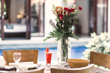 Flower bouquet at the table and pool in background