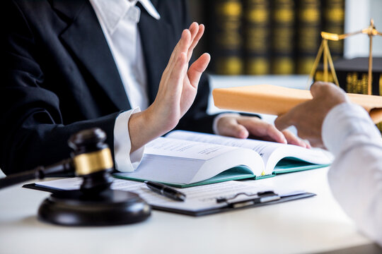 Close-up view of a lawyer refusing graft from a client,.make a deal agreement corruption, Judge gavel, brass scale,.law firm office, dishonest, law and justice advice service.