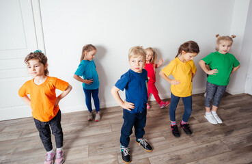 Group of children doing gymnastics in kindergarten or daycare