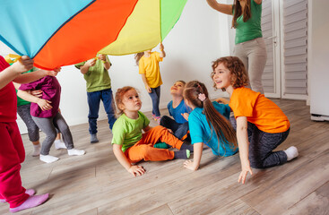 Organised team building games for kids using rainbow canopy