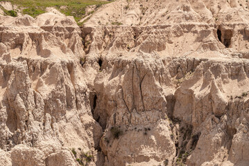 Badlands National Park, SD, USA - June 1, 2008: Detail of sharp beige canyons among peaks of geological deposits.