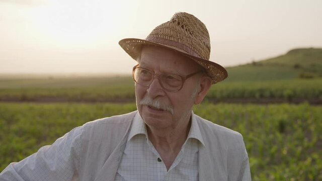 Close up view of a old farmer in hat and glasses
