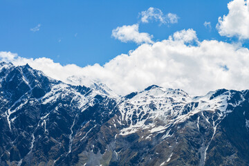 Landscape with majestic rocky peaks of mountains covered with snow on a clear day