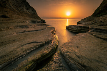 Beautiful sunrise on the rocky beach. Greek island Corfu