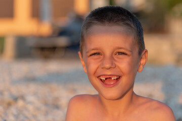 Fototapeta na wymiar Young toothless boy at the beach