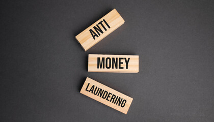 Anti Money Laundering word written on wood block. objective text on table, concept.