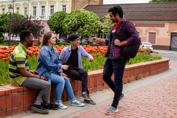 Fototapeta premium Group of happy friends in casual wear meeting on city street