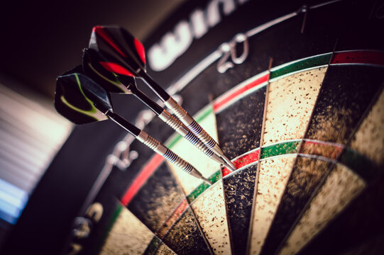 metal-tipped darts stuck in a competition cork dartboard