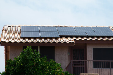 Close up of solar water panel heating on red tiled house roof with lightning protection skylights