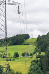 High voltage overhead power line, power pylon, steel lattice tower standing in the mountains landscape. Electricity distribution system in Europe