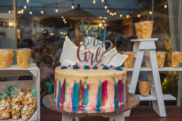 Gender reveal party cake and snacks table selective focus