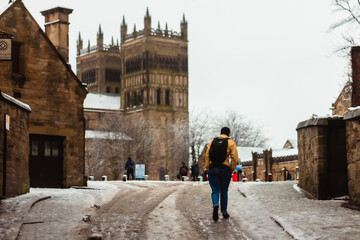 Student walking holding a backpack winter selective focus