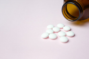 Close-Up View Of Medicine Spilling From Bottle yellow background.