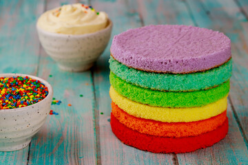 Obraz na płótnie Canvas Making colorful rainbow layered birthday cake with cream.