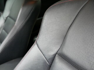 closeup of black leather car seat.
