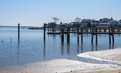 White sand beach, docks, pilings, and maritime village. Tranquil seascape over old piers in Hyannis on Cape Cod.