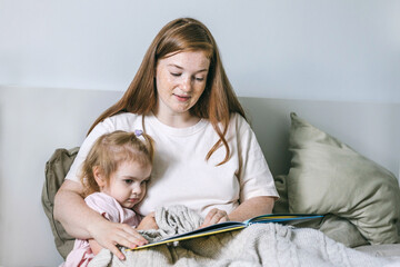 Mother and daughter read a book before bed. Evening ritual before bedtime, communication between parent and child