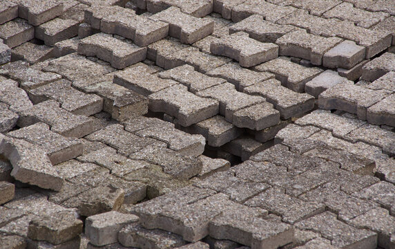 Stapel von alten Rasensteinen aus Beton warten auf ihren Einsatz
