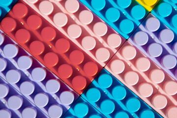 children's play background: the plane of plastic multi-colored bricks, blur, selective focus