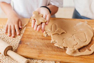 Little girl holding a cookie on her palm. Mother and little daughter bake cookies in the kitchen. Homemade food. Happy childhood